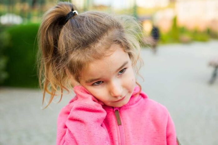A,Little,Girl,In,A,Pink,Hoodie,With,A,Sad