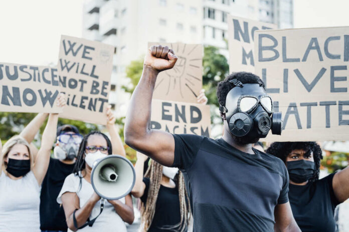 Activist,Wearing,Gas,Mask,Protesting,Against,Racism,And,Fighting,For