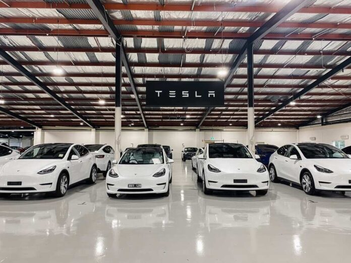 shutterstock_2190200775.jpg featured image White Tesla cars displayed in showroom with Tesla sign.