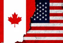 Canadian and American flags with torn dividing line