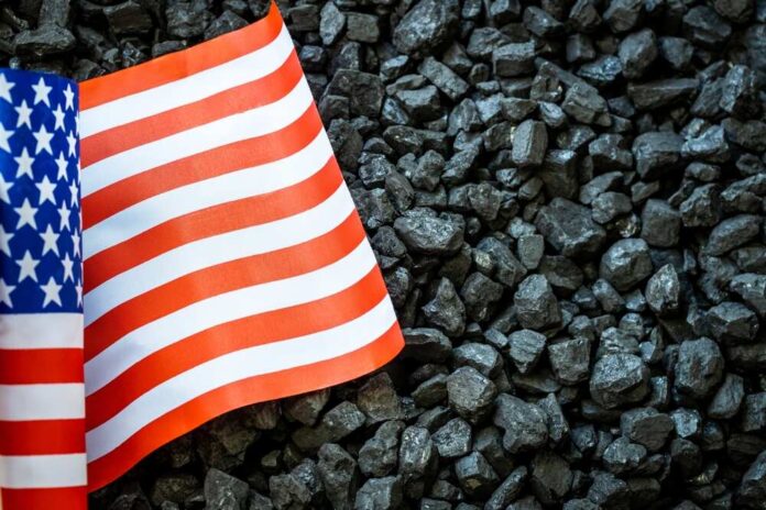 shutterstock_2161696223.jpg featured image US flag on pile of dark coal rocks