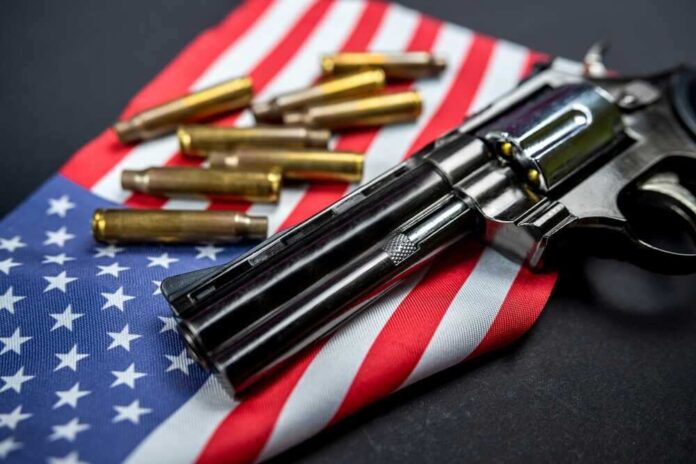 shutterstock_2206507241.jpg featured image Revolver and bullets on American flag background.