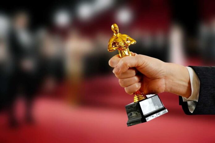 shutterstock_2428881627.jpg featured image Hand holding an Oscar award
