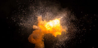 Bright explosion against a dark background with sparks.