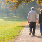Two people walking together on a park path.