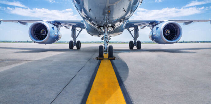 shutterstock_637037008.jpg featured image Airplane on runway with visible landing gear engines