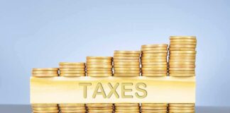 Stacked coins with TAXES on block beneath.