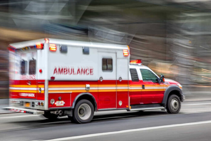 shutterstock_1495131698.jpg featured image Red and white ambulance driving on a city street.