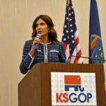 Kristi Noem speaking at KS GOP event podium.