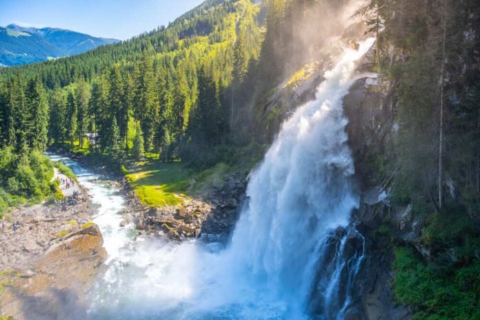 shutterstock_2342145113.jpg featured image Waterfall cascading down mountain surrounded by dense forest