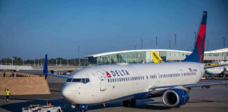 Delta airplane being towed at airport terminal gate
