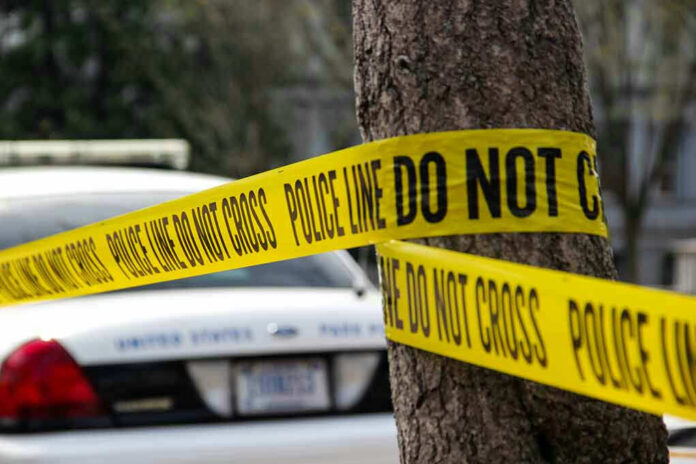 Police tape surrounding a tree and police car