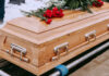 Wooden casket with red roses on top