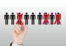 Hand crossing out stick figures with a red marker