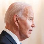 Joe Biden in a suit speaking, facing right.