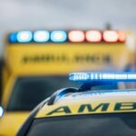 Ambulances with flashing lights on emergency scene.