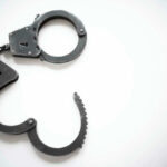 Open metal handcuffs on white background