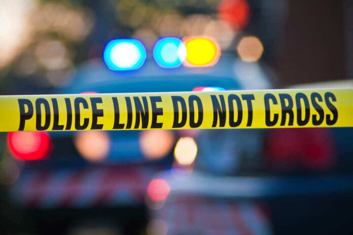 Police tape and lights at crime scene.