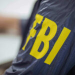 Person wearing FBI jacket letters in yellow