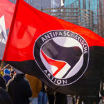 Protest with Antifascist Action flags and people outdoors