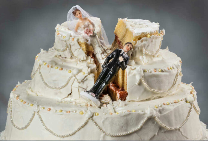 Wedding cake with bride and groom toppers, cake split