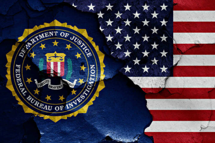 shutterstock_1023380488.jpg FBI seal superimposed on cracked American flag.