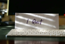 Envelope reading I Quit behind keyboard.