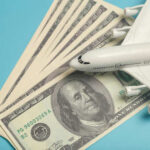 A model airplane placed on top of dollar bills