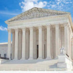 United States Supreme Court building with statues and columns.