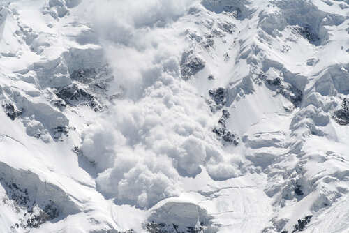 An avalanche cascading down a snowy mountain