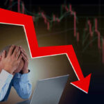 Man stressed over falling stock market graph.