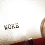 Close-up of the word 'WOKE' typed on paper from a typewriter