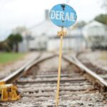 Deadly Train Derailment Exposes Dangerous Trade Gamble A blue derail sign on a railroad track