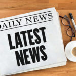 Newspaper with headline latest news on table