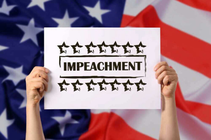 Hands holding impeachment sign over American flag.