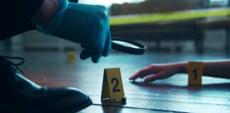 A detective examining evidence at a crime scene with markers on the floor