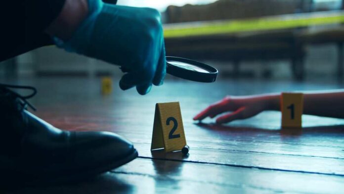A detective examining evidence at a crime scene with markers on the floor