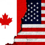 Canadian and American flags with torn dividing line