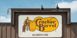 Sign for Cracker Barrel Old Country Store featuring a man sitting on a barrel
