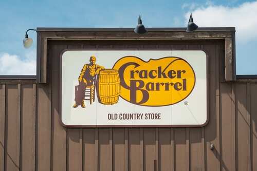 Sign for Cracker Barrel Old Country Store featuring a man sitting on a barrel