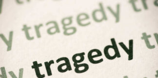 Close-up of the word 'tragedy' printed multiple times in varying shades
