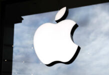 Illuminated Apple logo on a glass storefront