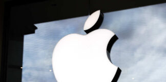 Illuminated Apple logo on a glass storefront