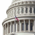 Trump Budget Shakes Congress U.S. Capitol dome with American flag flying.