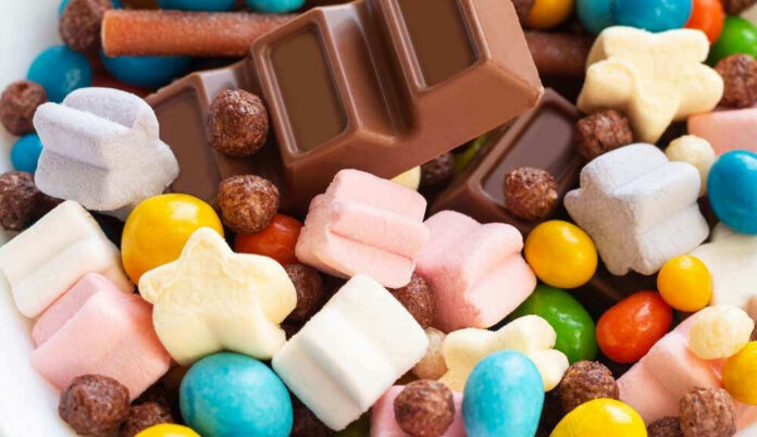 shutterstock_2172876293.jpg Colorful candies and chocolate bar close-up.