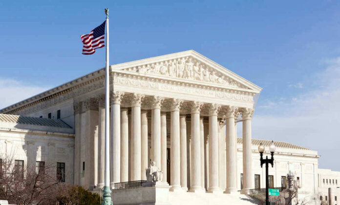 shutterstock_96721225.jpg U.S. Supreme Court building with American flag.