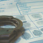 Handcuffs on a fingerprint document.