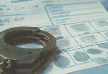 Handcuffs on a fingerprint document.
