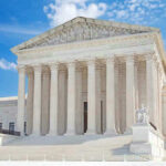 United States Supreme Court building with statues and columns.