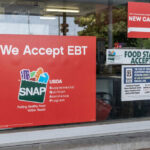 Store window displays EBT and SNAP acceptance signs
